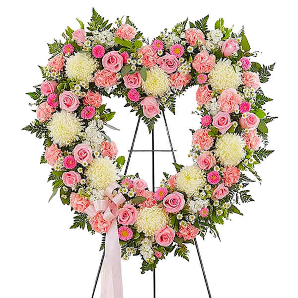 Heart-shaped floral wreath on an easel with pink and white flowers
