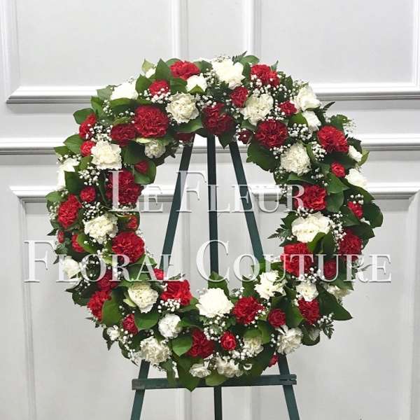 Red and white floral wreath on a standing easel