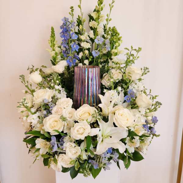 White and blue floral arrangement in a metallic vase