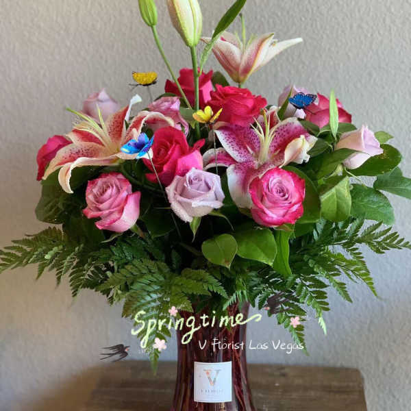 Pink roses and lilies arranged in a glass vase