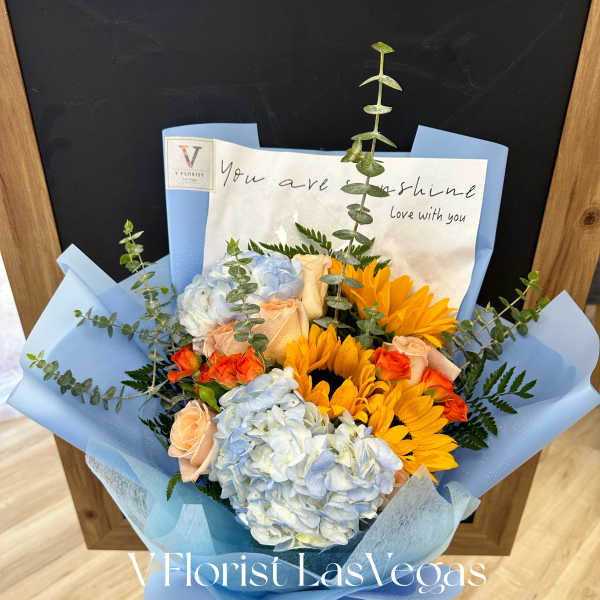 Blue and peach bouquet with hydrangeas, roses, and sunflowers