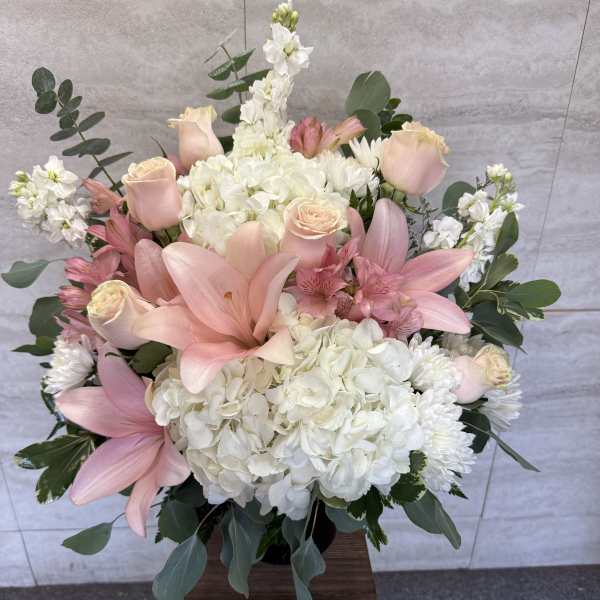 Pink lilies and roses with white hydrangeas in a vase