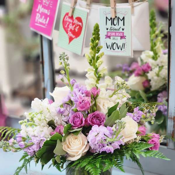 Mixed pink, white, and lavender flowers in a glass vase