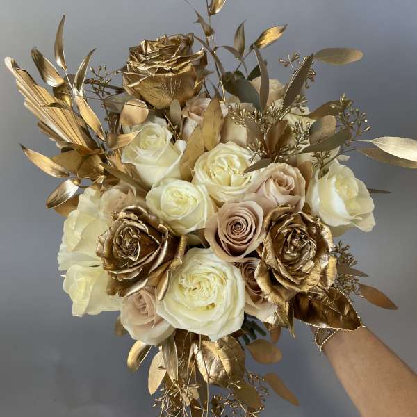 Bouquet of cream and gold roses with metallic foliage