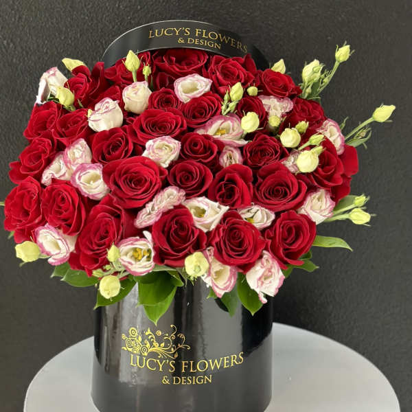 Red and white roses arranged in a black hatbox