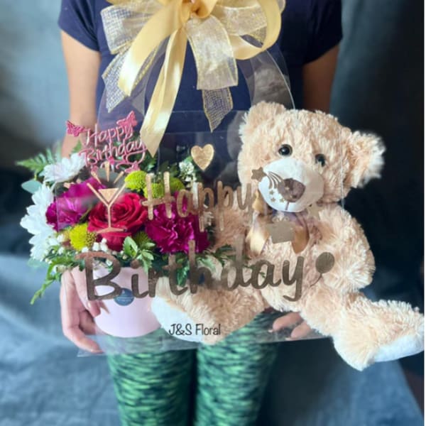 Birthday flower gift with a teddy bear and pink roses in a box