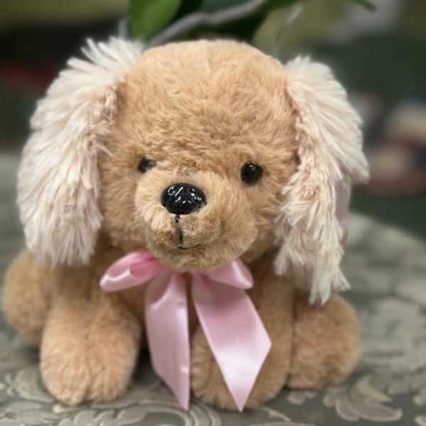 Plush teddy dog with a pink ribbon bow