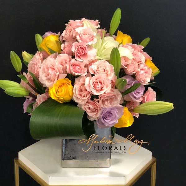 Pink and yellow rose bouquet in a square metal vase