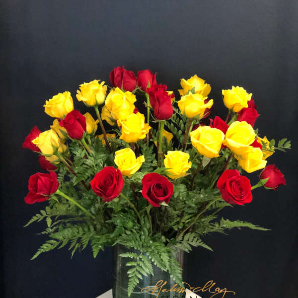 Red and yellow roses arranged in a glass vase