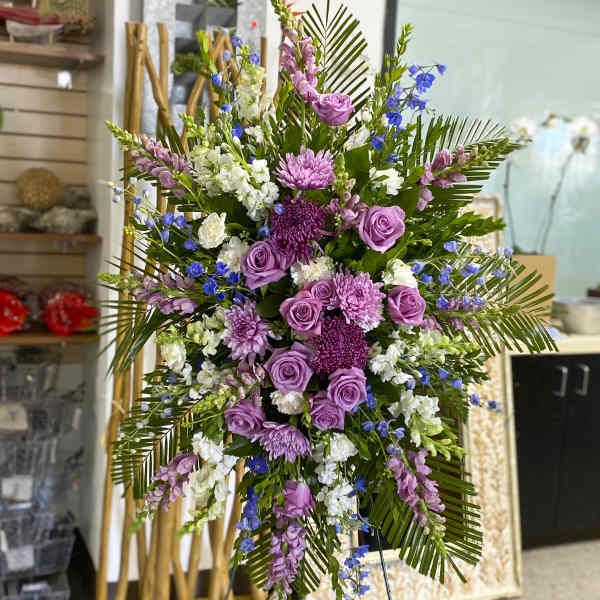 Tall floral spray with purple roses, chrysanthemums, and blue accents