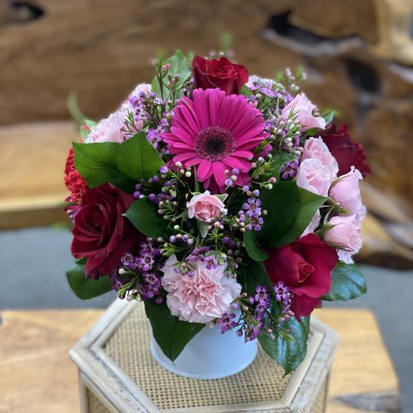 Bouquet of pink and red flowers in a white vase