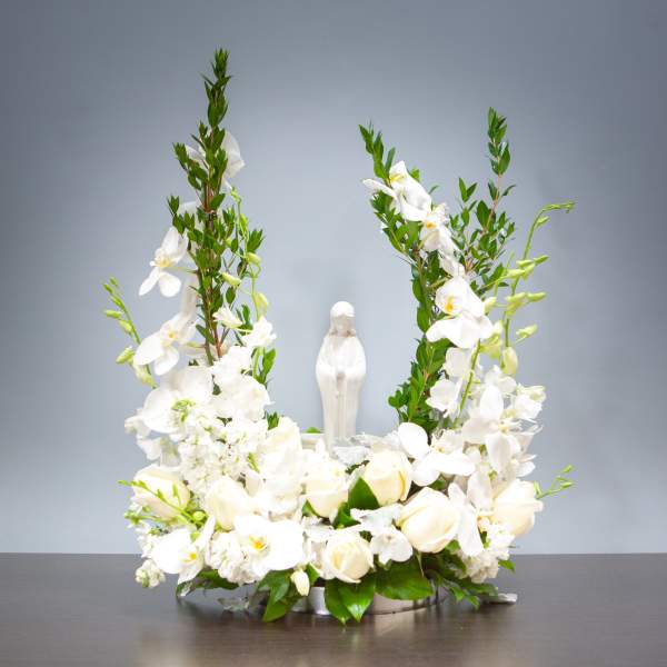 White floral arrangement with a small statue in the center