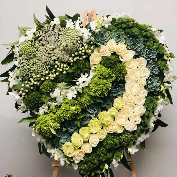 Heart-shaped floral wreath with cream roses and green succulents