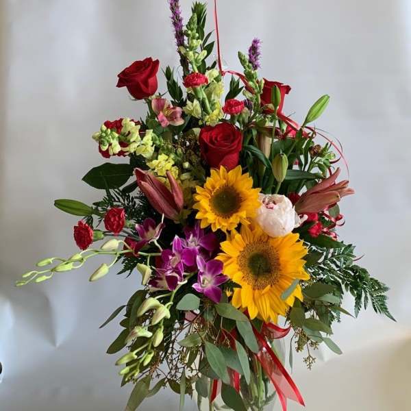 Mixed bouquet with red roses, sunflowers, lilies, and orchids