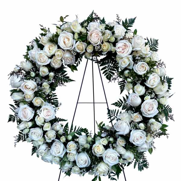 White rose wreath on a black stand