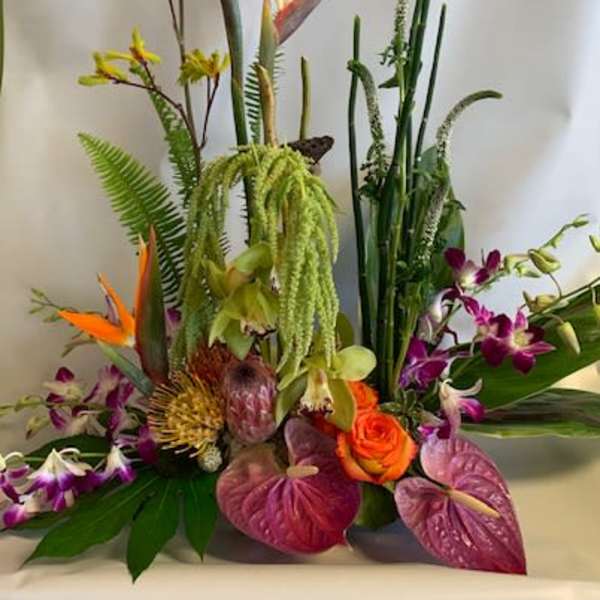 Tropical flower arrangement with orange bird-of-paradise and purple orchids