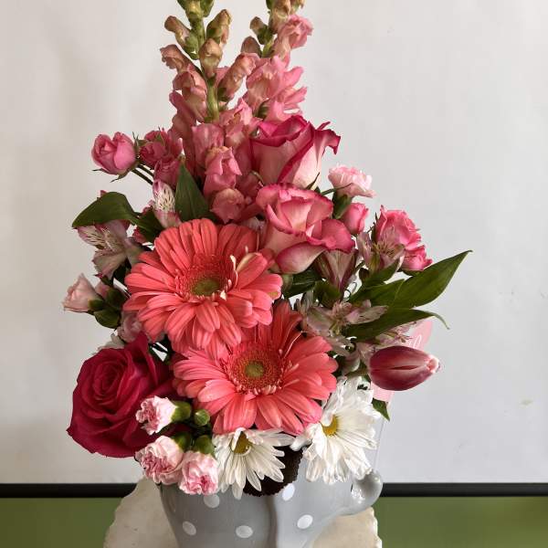 Pink and white mixed flower arrangement in a gray polka-dot vase