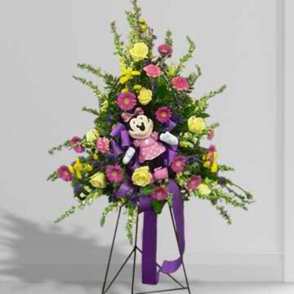Tall floral standing spray with a teddy bear and purple ribbon