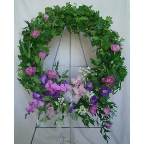 Floral wreath with pink and purple flowers on a metal stand