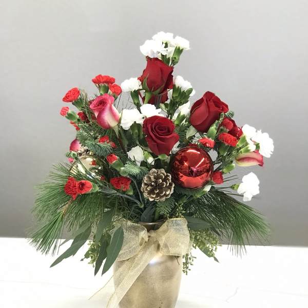 Holiday bouquet of red roses and white carnations in a gold vase