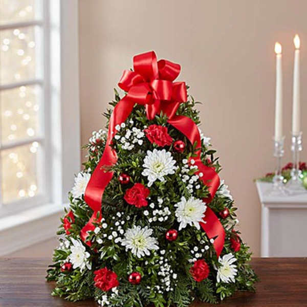 Christmas tree-shaped floral arrangement with red ribbon and white flowers