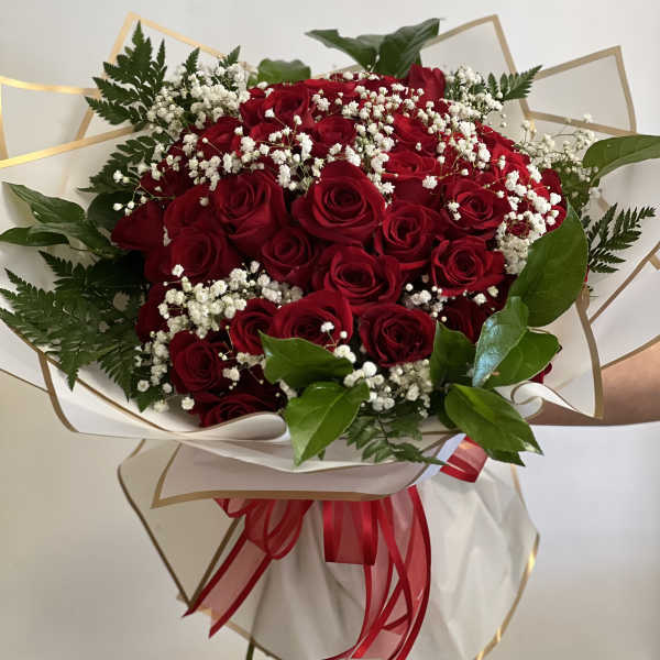 Bouquet of red roses with white baby's breath and greenery