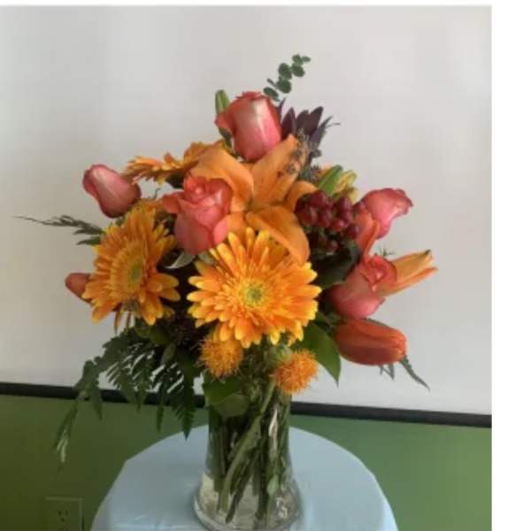 Orange and pink mixed bouquet in a clear glass vase