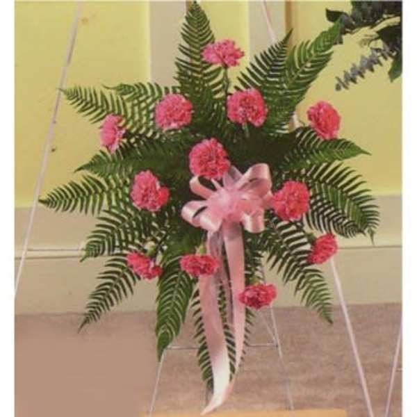 Standing spray of pink carnations with a pink ribbon on an easel