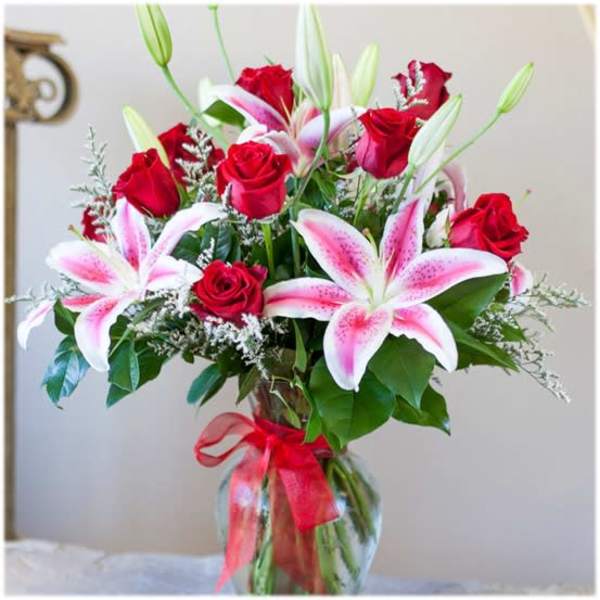 Bouquet of red roses and pink lilies in a glass vase