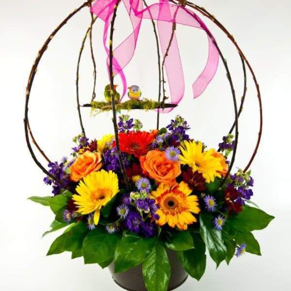 Colorful flower basket with a pink ribbon bow and birdcage topper