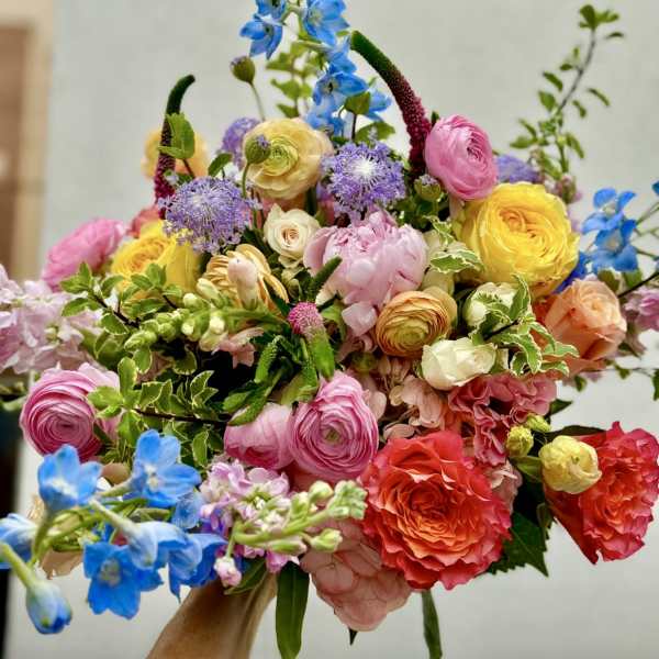 Colorful bouquet with pink, yellow, blue, and coral flowers
