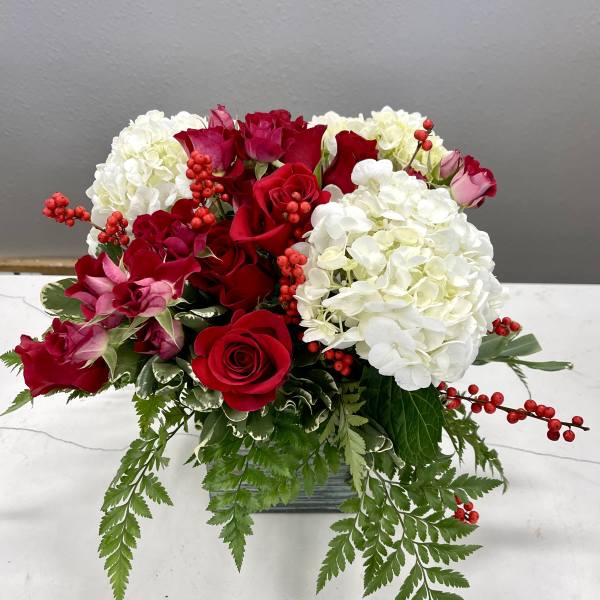 Red roses and white hydrangeas in a low rectangular vase