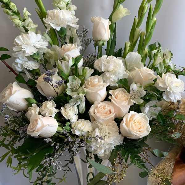 White and blush floral arrangement in a clear glass vase