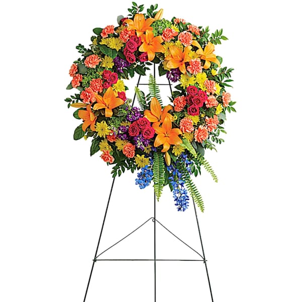 Colorful funeral wreath on a black easel stand