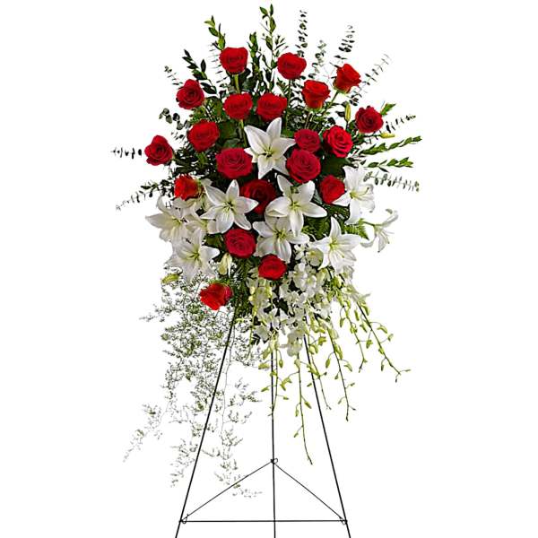 Standing floral spray of red roses and white lilies on an easel