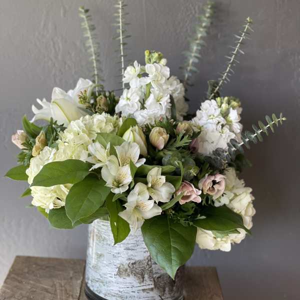 White floral arrangement in a birch-pattern vase with tall stems