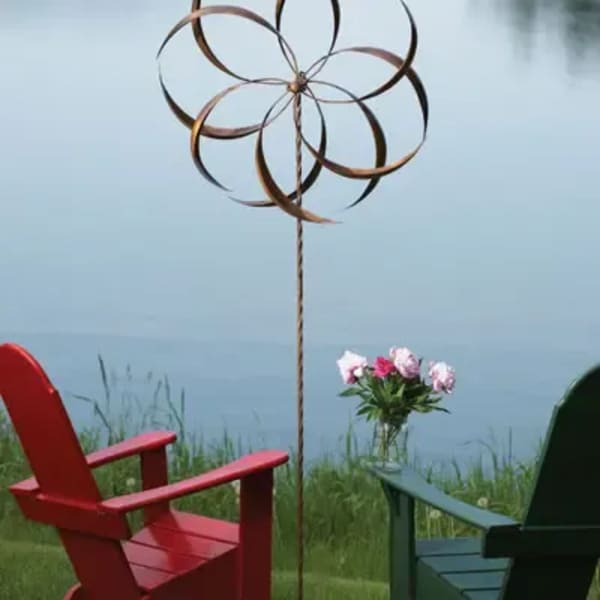 Small bouquet of pink flowers in a clear vase beside two chairs