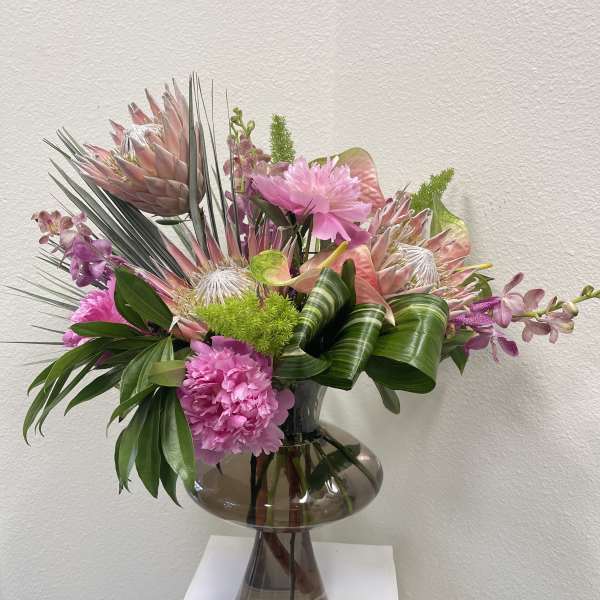 Pink tropical bouquet in a smoked glass vase