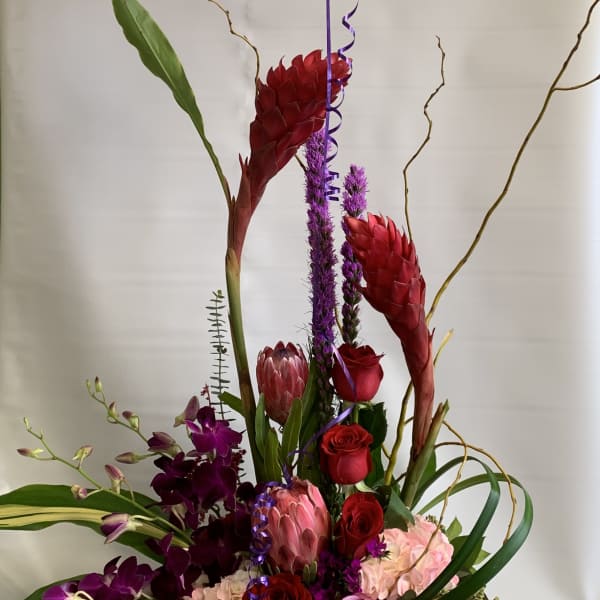Tall floral arrangement with a thank-you balloon and mixed blooms in a vase