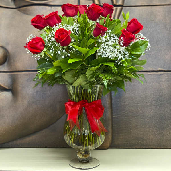 Bouquet of red roses in a glass vase with a red ribbon