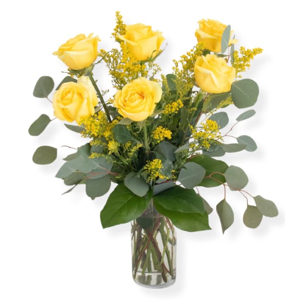 Yellow roses in a clear glass vase with airy filler flowers