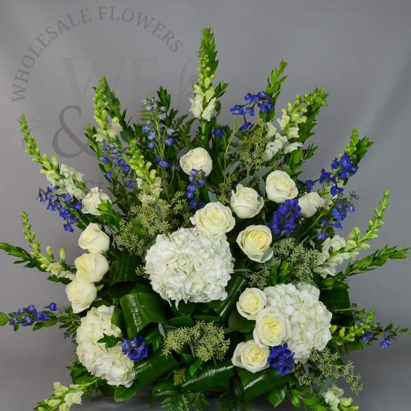 White hydrangeas and roses with blue flowers in a large arrangement