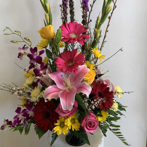 Tall mixed bouquet with lilies, gerbera daisies, roses, and orchids