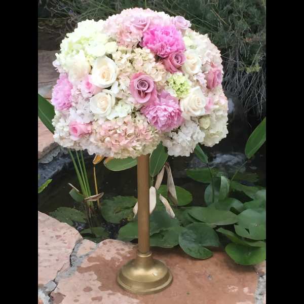 Pink and white floral arrangement on a gold stand