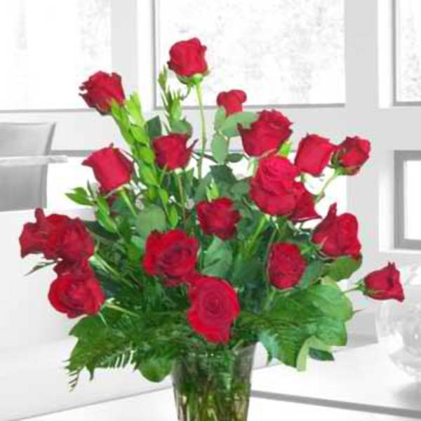 Red roses arranged in a clear glass vase