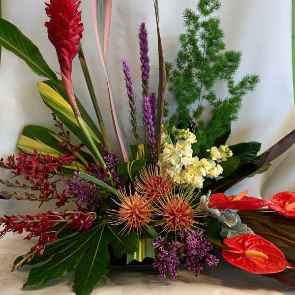 Tropical floral arrangement with red ginger, purple blooms, and red anthuriums