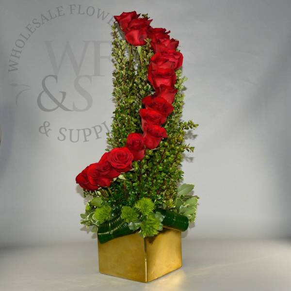Tall arrangement of red roses with greenery in a gold box