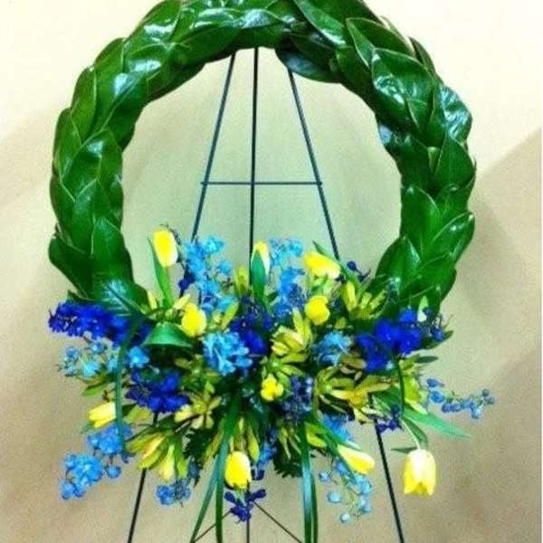 Blue and yellow floral wreath on a black easel
