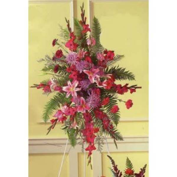 Tall floral standing spray with pink and red flowers on an easel