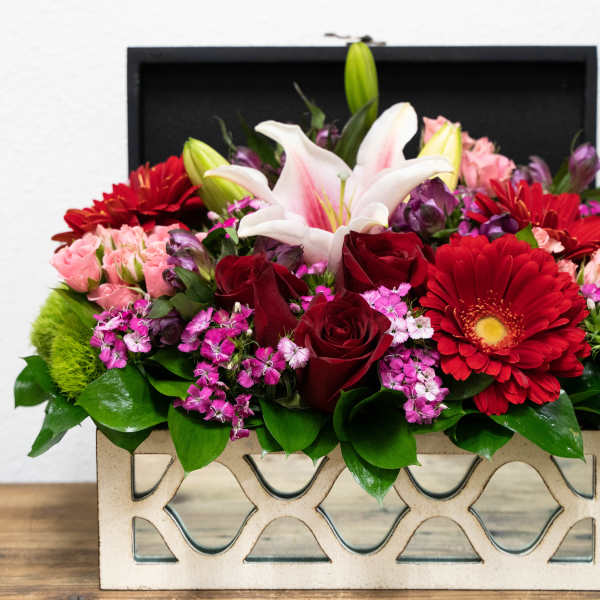Mixed bouquet in a decorative rectangular box with red, pink, and white blooms